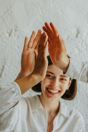 People hi-fiving each other in a business setting